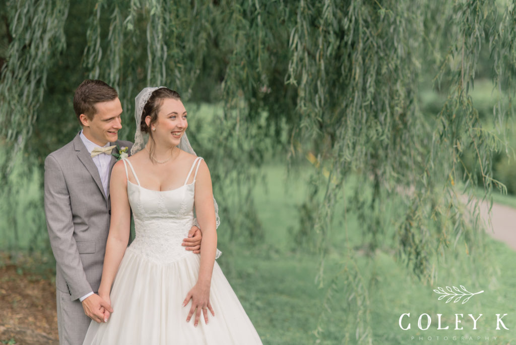 Bride and Groom smiling in front of Willow Tree by Asheville Wedding Photographer