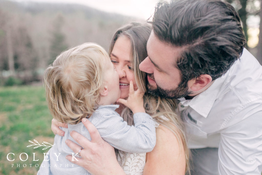 Toddler kisses Mom and Dad Family Photograph in Asheville Mountains Family Photographer